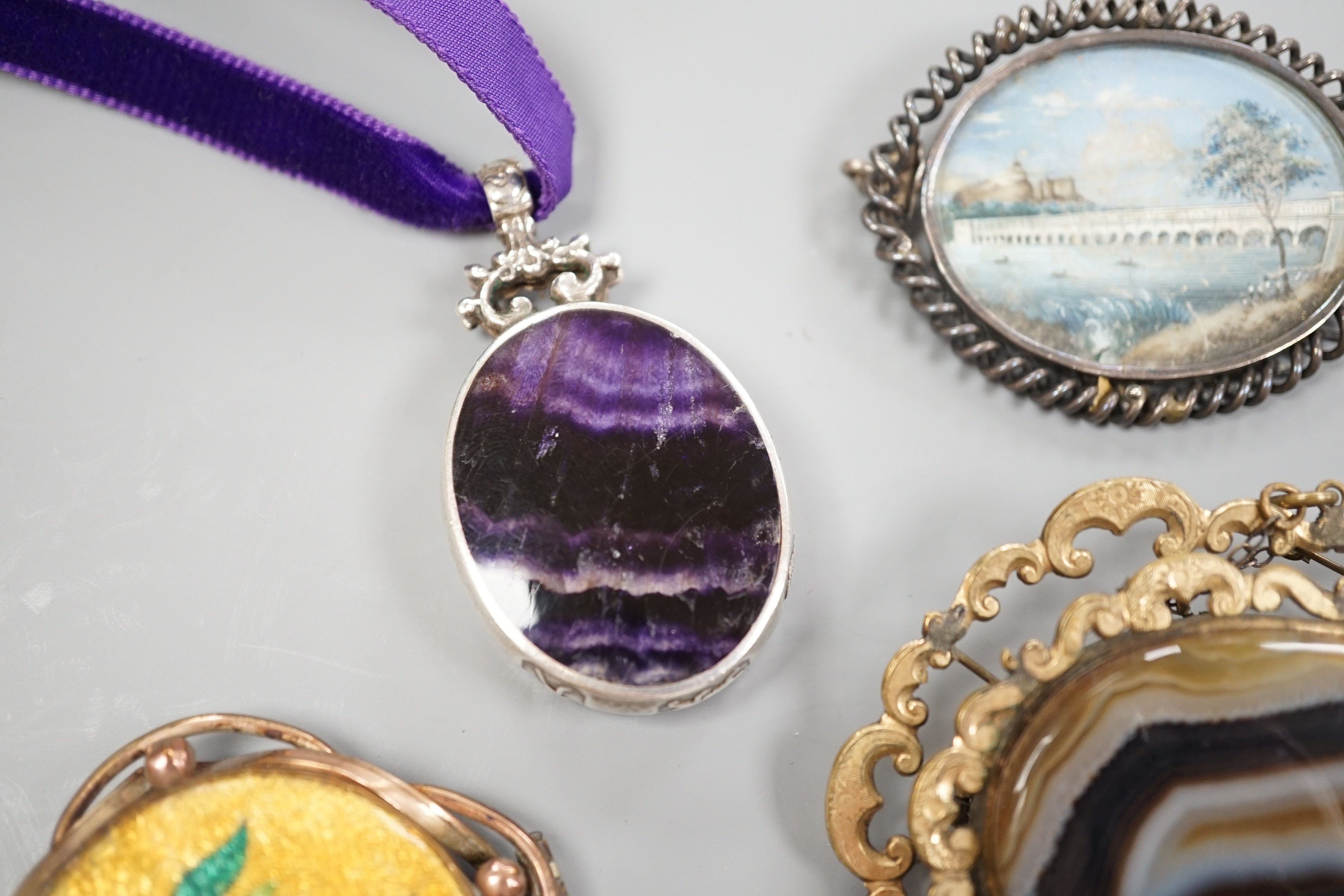 A modern silver mounted bluejohn oval pendant and three other brooches including banded agate.